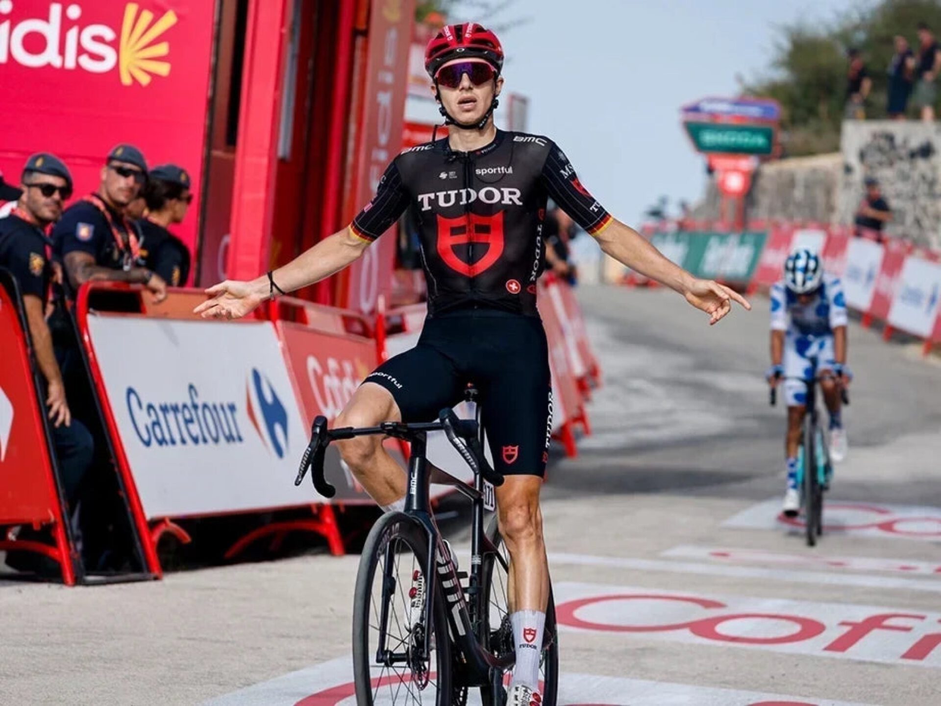 Marco Brenner juicht met gespreide armen bij de finish van de veertiende Vuelta-etappe