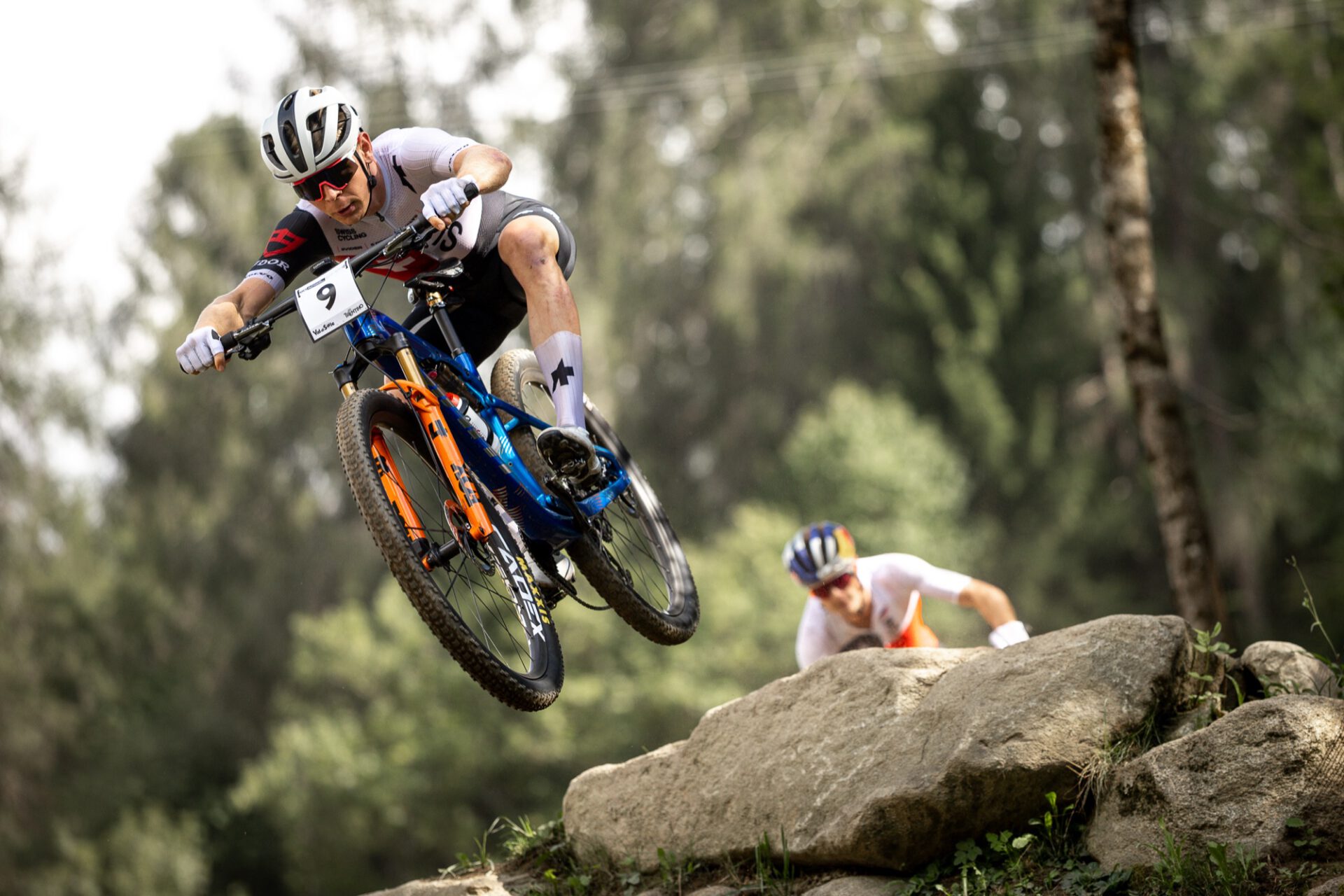 Renner vom Giant Factory Off-Road Team springt über einen Felsblock auf den CADEX Max XC-Rädern
