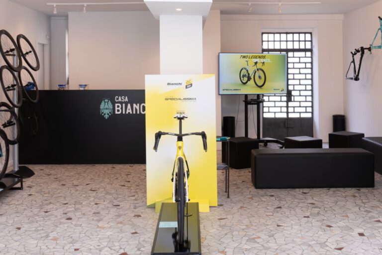 Interieur van de pop-up Casa Bianchi in Milaan met een gele Bianchi-racefiets op de voorgrond