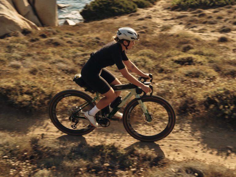 Renster op de groene Colnago G5-X op een gravelpad langs de kust