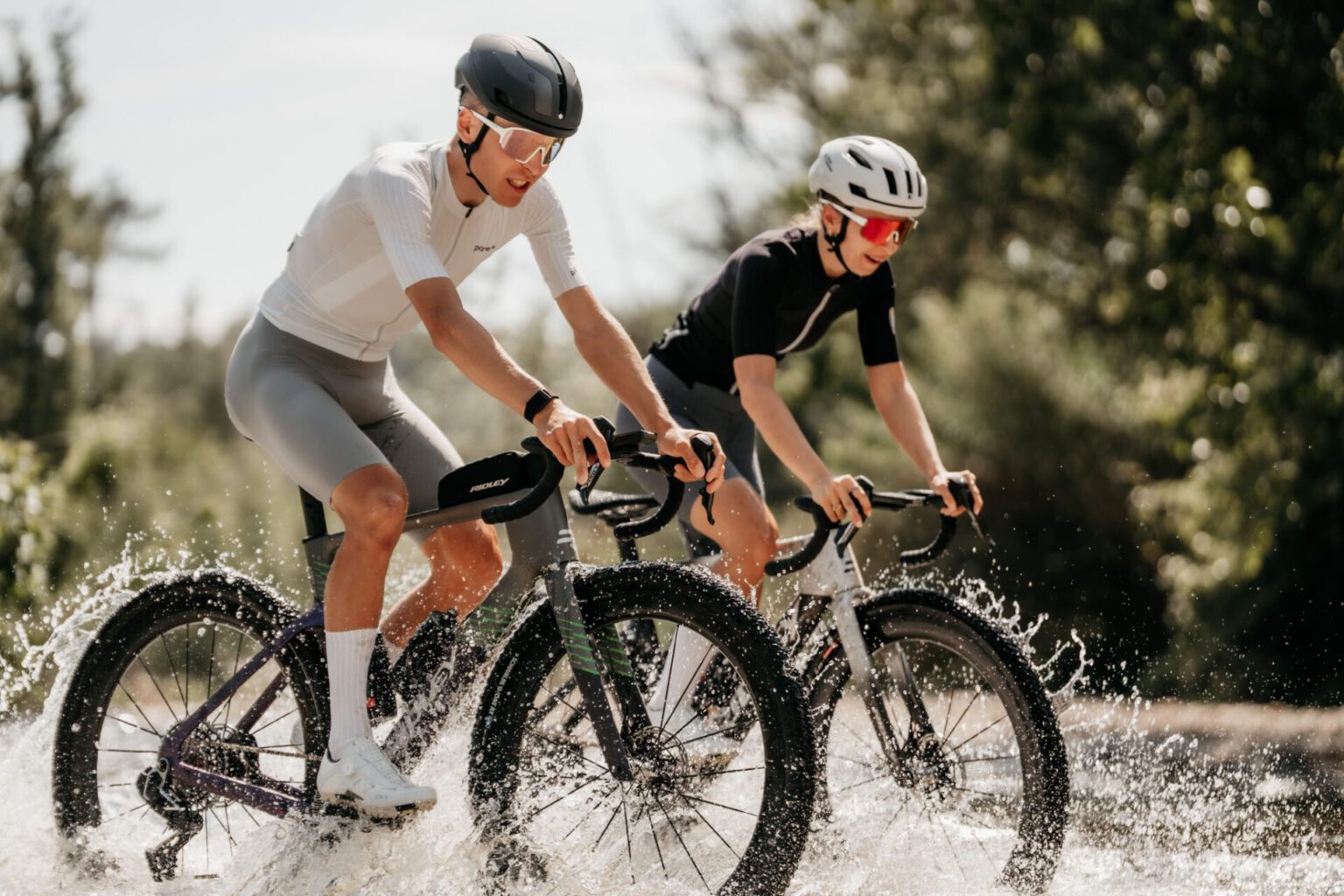 Two riders on the Ridley Kanzo Fast 2.0 are riding through a shallow river