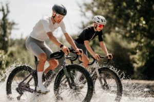 Twee rijders op de Ridley Kanzo Fast 2.0 rijden door een ondiepe rivier