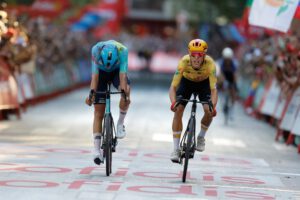 Twee renners sprinten naast elkaar naar de finish van de slotrit van de Vuelta in Granada