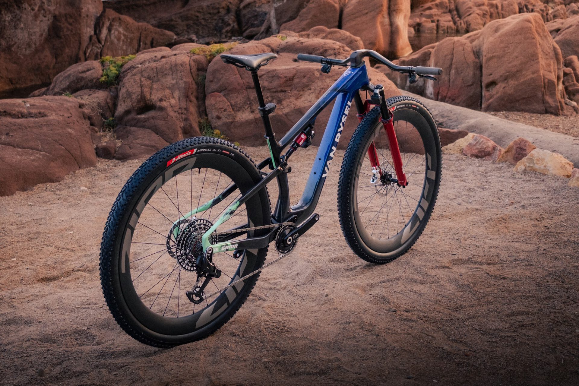 De Van Rysel RCR-XC schuin van voren tussen rode rotsen, met 32 inch wielen