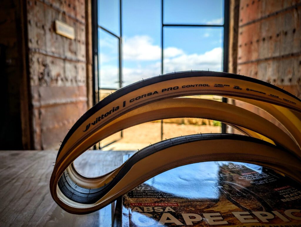 Twee Vittoria Corsa PRO Control 42 mm-banden met tanwall op een houten tafel