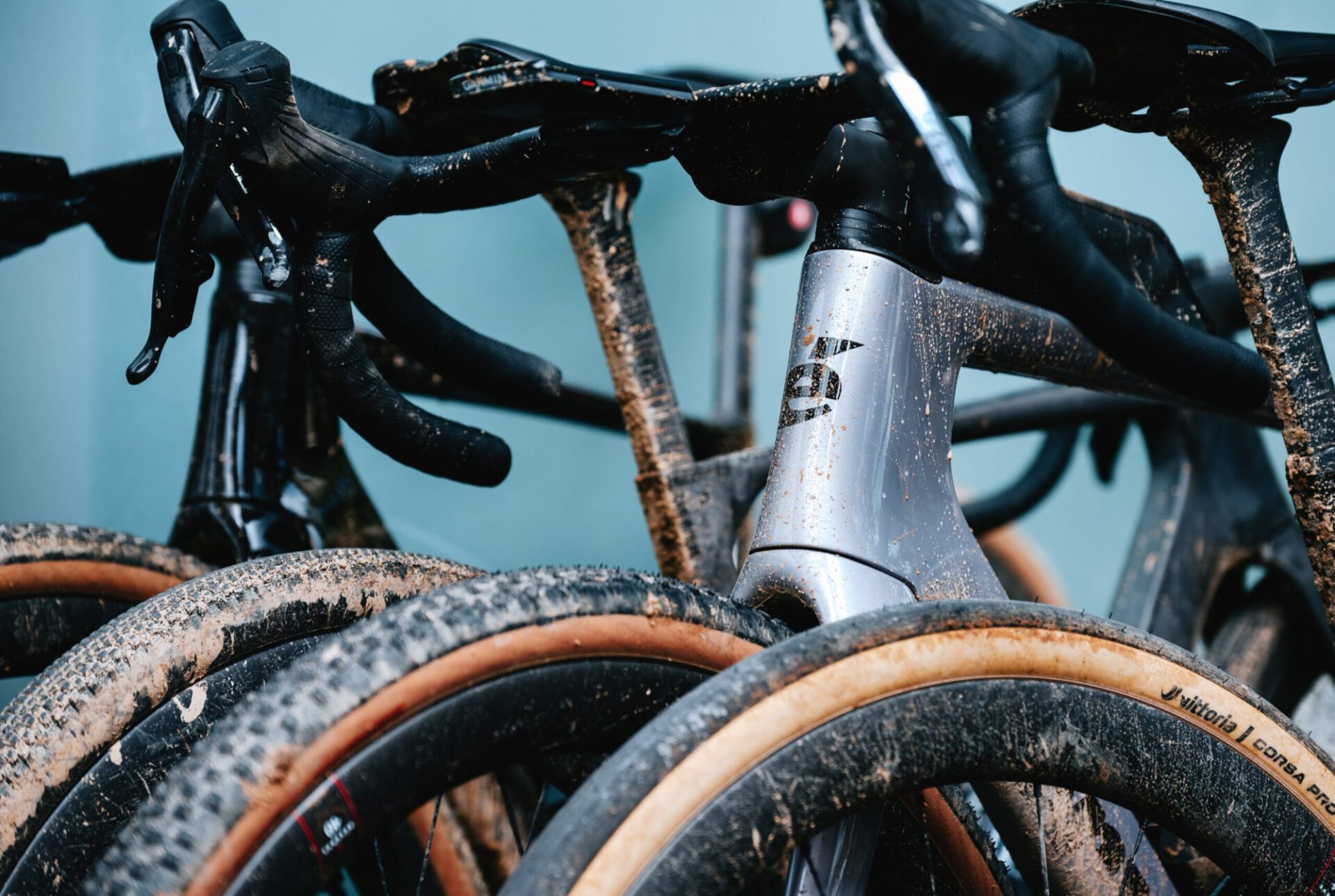 Modderige gravelbikes naast elkaar, vooraan een wiel met een Vittoria Corsa PRO Control-band